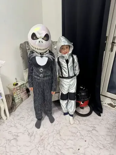 Two children dressed up in costumes standing next to each other